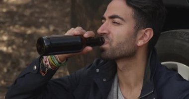 Yol yardımını beklerken bira içen çekici İspanyol adam.