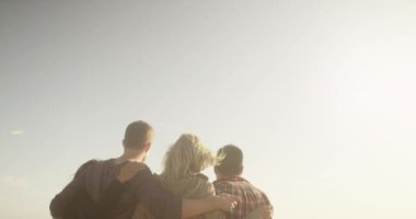 Bir grup arkadaş birlikte okyanusa doğru bakıyorlar.