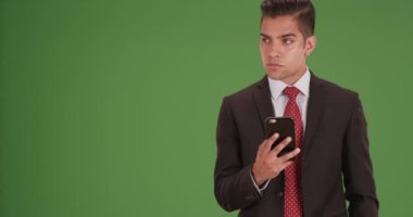 Milenyum iş adamı, iş arkadaşlarıyla çevrili bir şekilde yeşil ekranda kendi akıllı telefonlarını kullanarak mesajlaşıyor. Anahtar ya da birleşik olmak üzere yeşil ekranda.