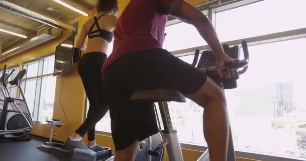 Hispanic Woman Working Out Gym Elliptical While Man Gets Bike — Stock Video