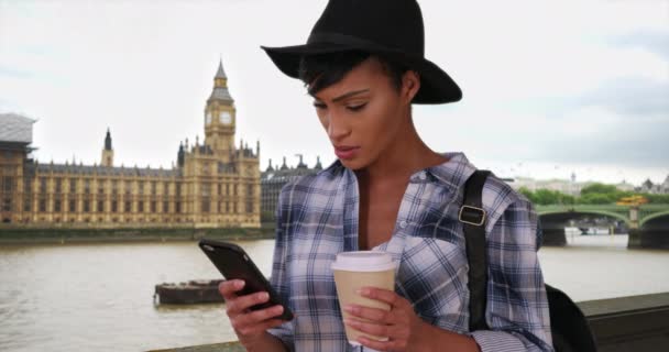 Молодая Черная Миллениал Читает Своем Телефоне Лондоне Биг Беном Вдалеке — стоковое видео