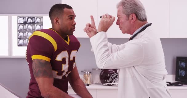 Pemain Sepak Bola Perguruan Tinggi Memiliki Dokter Senior Meninjau Cedera — Stok Video