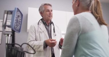 Orta yaşlı doktor Bayan hasta için konuşuyor