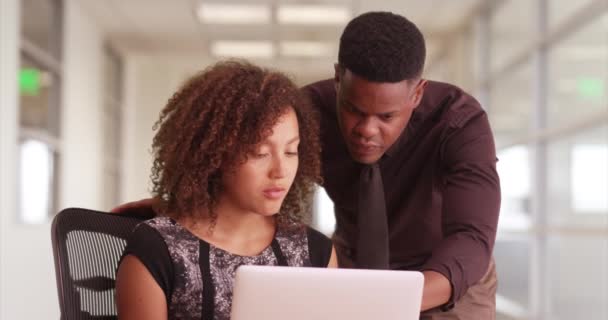 非裔美国男性和女性在办公室走廊的笔记本电脑上工作 两个千年级的黑人商人在看笔记本电脑 — 图库视频影像