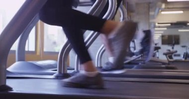 Spor salonundaki koşu bandında alçak açıyla koşan ayakları kapat.
