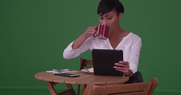 黑人妇女坐在桌边喝咖啡 在绿色屏幕上吃午饭 在绿色屏幕上键入或合成 — 图库视频影像