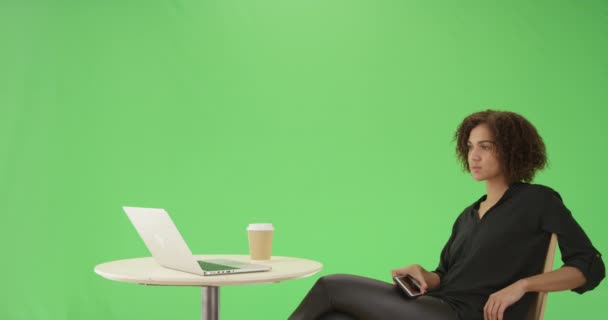 一位千禧年的非洲裔美国女商人坐在她的绿色屏幕上的手机上的咖啡桌旁 在绿色屏幕上键入或合成 — 图库视频影像