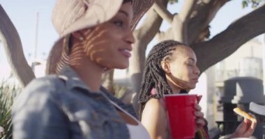 Parkta pizza yiyen iki Afrikalı Amerikalı en iyi arkadaş.