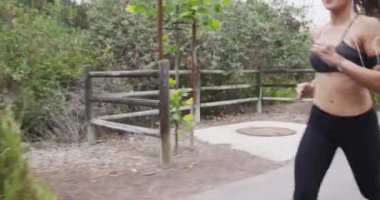 Parkta müzik dinleyen mutlu Atletik Asyalı kadın