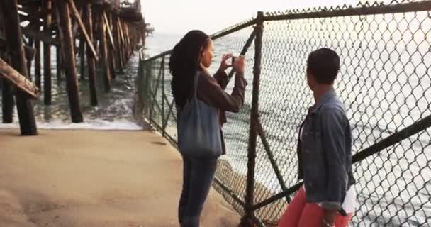 Черная Женщина Фотографирует Закат Мобильного Телефона Стоя Пирсом — стоковое видео