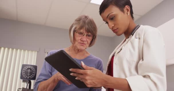 患者でタブレットを見て若いのインテリジェントな医者 — ストック動画
