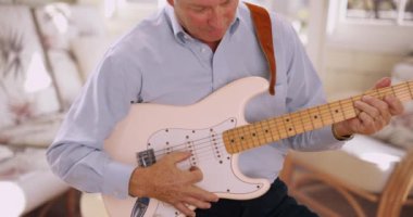 Gitar çalan son sınıf erkek gitaristin portresi. Elektro gitarla pratik yapan usta bir müzisyen..
