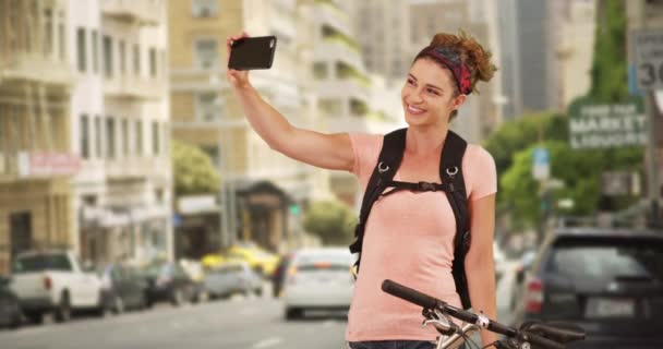 Millennial Usando Smartphone Para Hacerse Autorretratos Mientras Pedalea Por Ciudad — Vídeos de Stock