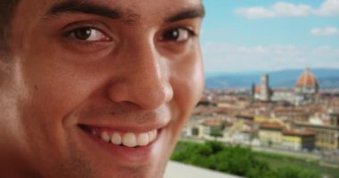20 'li yaşlarda Floransa' da tatil yapan Latin bir erkeğin gülümseyen portresi. Direk olarak kameraya bakan mutlu, çekici İspanyol adama yaklaş. 4k