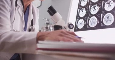 Olgun beyaz nörolog bakarak kadın x-ışınları