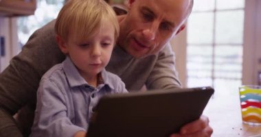 Sevimli genç beyaz çocuk tablet bilgisayar kullanmayı öğrenme