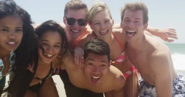 Grup portresi genç Interracial arkadaşlar kumsal zevk sokulmuş