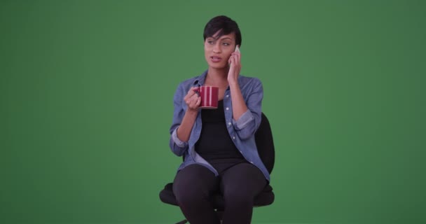 Молодая Африканская Американка Офисном Кресле Пьет Кофе Улыбается Разговаривая Смартфону — стоковое видео