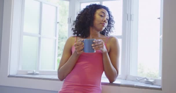 アフリカ人女性が窓際でコーヒーを飲む — ストック動画