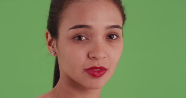 一个戴着红色口红的拉丁女孩的特写头像 在绿色的屏幕上看着别处 在绿色屏幕上键入或合成 — 图库视频影像