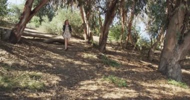 Genç beyaz hippi kadın kirli yolda koşuyor.