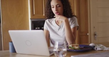 Laptop bilgisayarında yazan çekici bir Latin kadın.