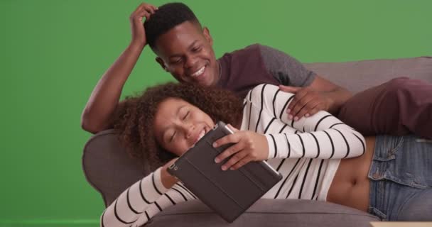 快乐的黑色千年夫妇在他们的平板电脑上观看一个视频的绿色屏幕 在绿色屏幕上键入或合成 — 图库视频影像