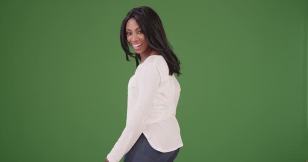 美丽的非洲裔美国女人穿着绿色屏幕上的白色毛衣 在镜头前开心地微笑着 在绿色屏幕上键入或合成 — 图库视频影像