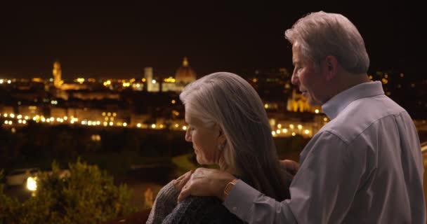 大人の白人男性と女性がフィレンツェの街並みを眺めながら親密な時間を過ごしています 古いコーカサス人のカップルは イタリアのフィレンツェを旅行しながらロマンチックな夜をお楽しみください — ストック動画