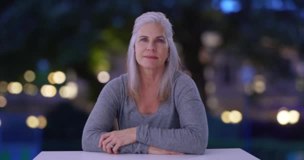 Σοβαρή Ώριμη Λευκή Γυναίκα Κάθεται Ένα Υπαίθριο Τραπέζι Βράδυ Κοιτάζει — Αρχείο Βίντεο