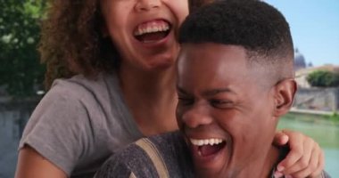 Roma 'daki Arno Nehri' nin kenarında gülümseyen ve sevgi dolu olan bin yıllık şirin bir çiftin portresi. Neşeli siyah erkek ve kadın gülüyor, balayının tadını çıkarıyorlar. 4k