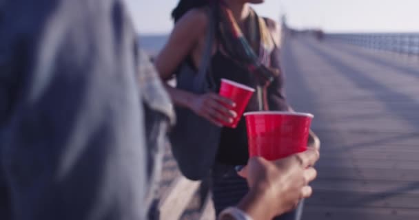 Ahşap Korkuluklara Dayanan Iki Kadın Arkadaşın Tuttuğu Kırmızı Plastik Bardakları — Stok video