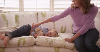 Sevimli genç çocuk yorgun ve uzanmış görünüyor.