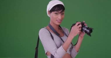 Fotoğrafçı kadın yeşil ekranda kameraya doğru bakıyor. Anahtar ya da birleşik olmak üzere yeşil ekranda.