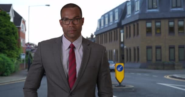 一个有抱负的黑人男性商人站在一个欧洲城市的外面 成功的非洲专业人士穿着西装打领带 自信地看着街上的摄像机 — 图库视频影像