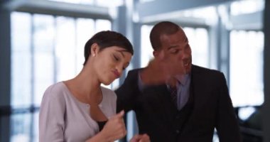 Oyuncu Afro-Amerikan profesyoneller iş yerinde birlikte dans ediyorlar. Siyahi erkek ve kadın iş adamları çalışırken dans ederken eğleniyorlar. 4k