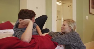 Çift yatak odasında konuşuyor ve gülüyor.