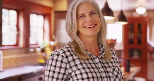 魅力的な中年の白人女性の肖像画笑顔 中年女性見ます幸せで家キッチン — ストック動画