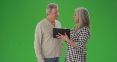 Tablet cihazına bakan yaşlı bir çiftin portresi