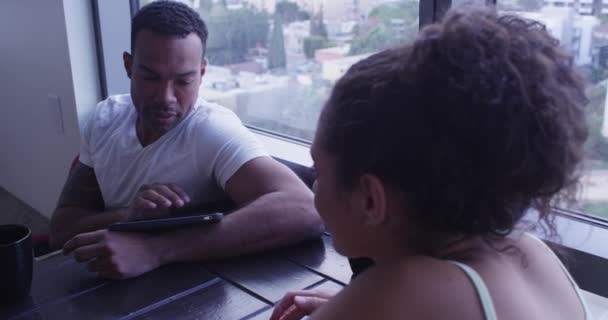 多族裔夫妇在客厅里聊天 使用电话和平板电脑 — 图库视频影像