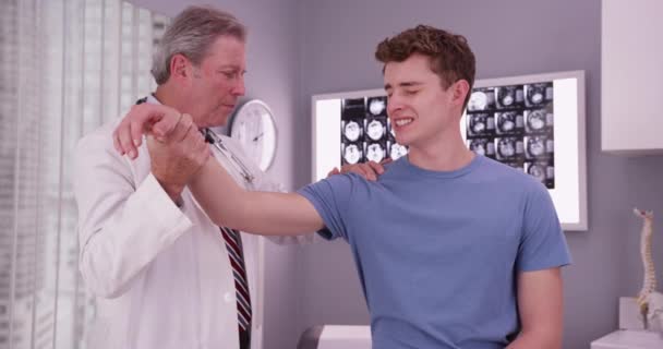 Yakışıklı Beyaz Erkek Hasta Omzundan Yaralanmış Doktor Tarafından Muayene Ediliyor — Stok video