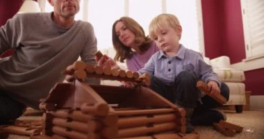 Sevimli küçük çocuklu aile ile ahşap bir ev inşa