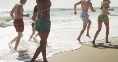 Çok etnik arkadaşlar plaj sahil çalışan mutlu Grup