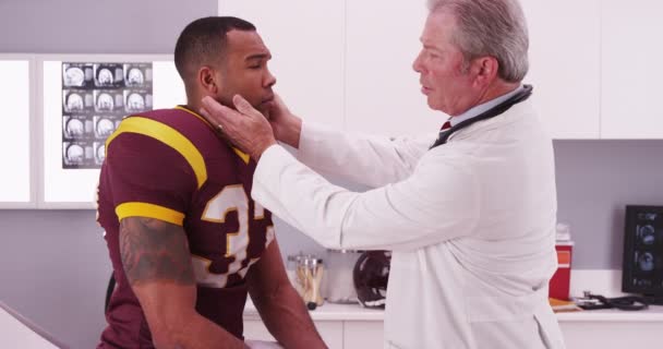 医療医師チェック首の負傷を持つ大学サッカー Athete — ストック動画