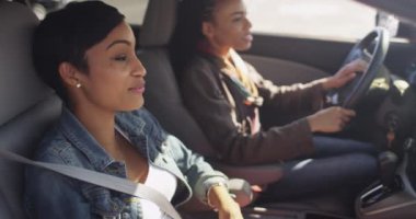 Arkadaşlar arabada otururken konuşuyor ve şakalaşıyorlar.