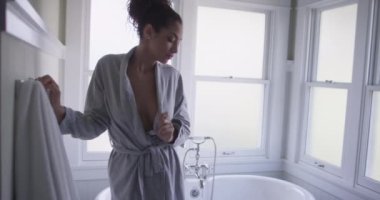 Küvetin yanında duran çekici Latin kadın.