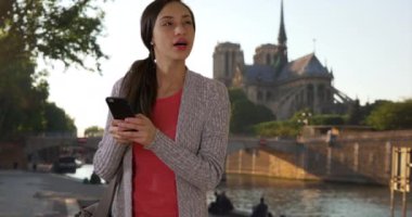 Notre Dame yakınlarında cep telefonunda birini bekleyen çekici Latin kadın mesajları. Şirin, gülümseyen İspanyol bir kadın arkadaşıyla buluşuyor, cep telefonundaki mesajlar. 4k