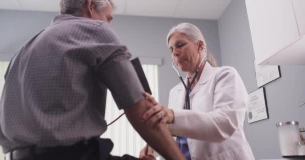 Médico Que Revisa Presión Arterial Del Paciente Masculino Mediana Edad — Vídeos de Stock