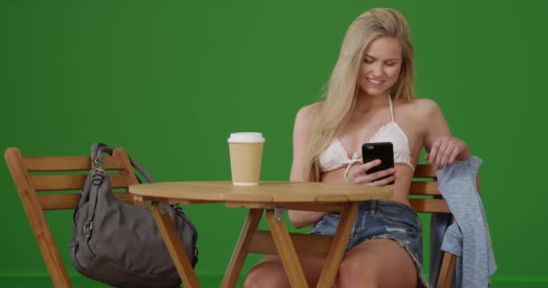 Akıllı Telefonuyla Yeşil Ekranda Bikinili Bir Masada Oturan Genç Bir — Stok video