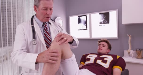Κολεγιακός Ποδοσφαιριστής Τραυματισμό Στο Γόνατο Εξετάζεται Από Γιατρό — Αρχείο Βίντεο